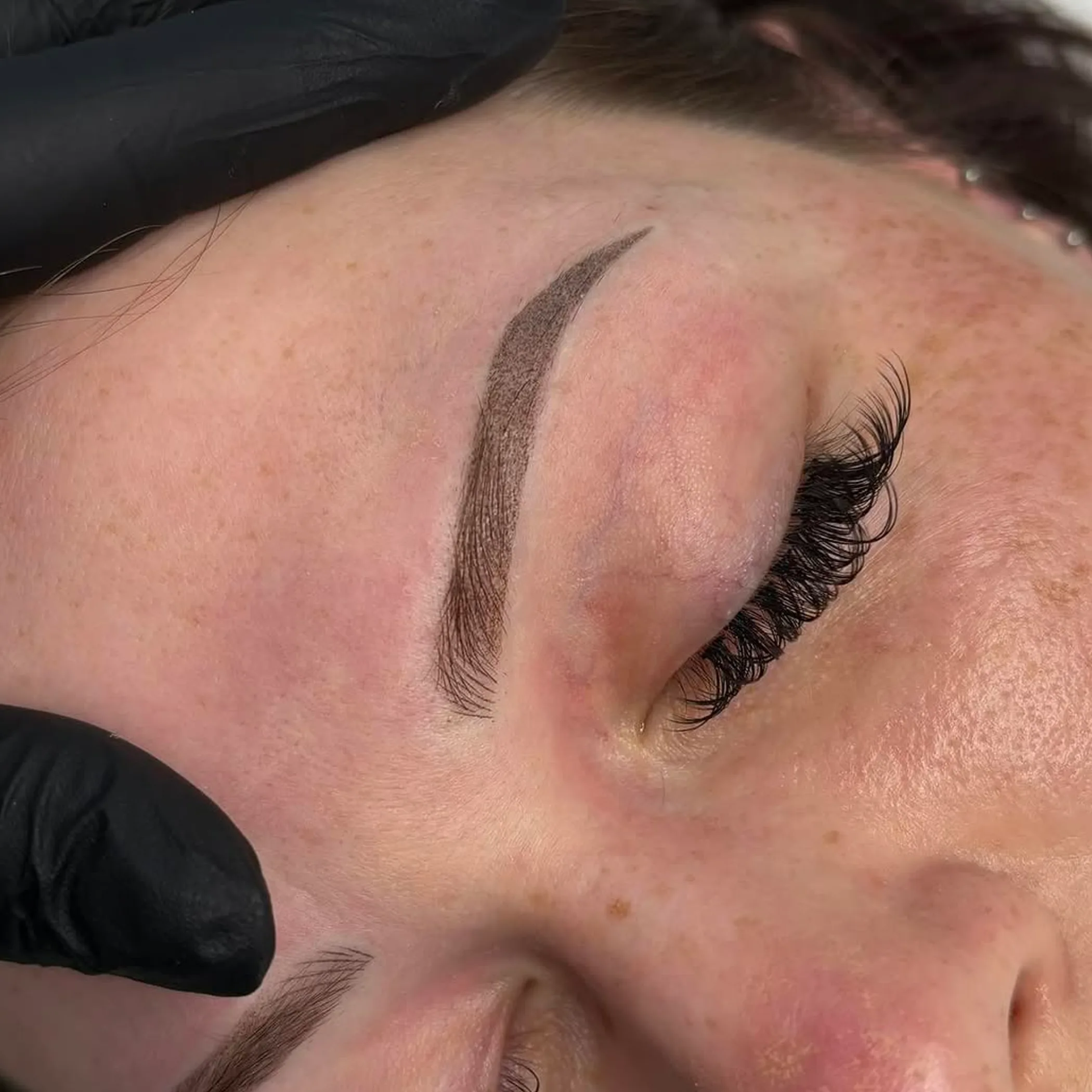 client lying down during combination brow procedure