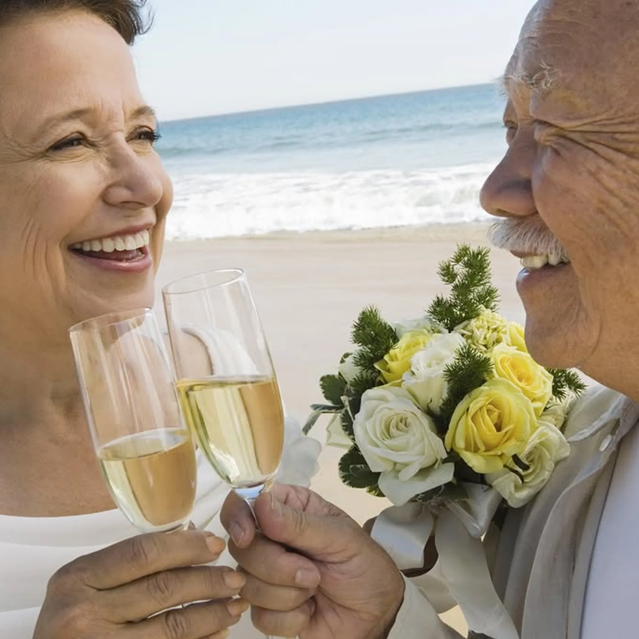 older couple celebrating love by beach